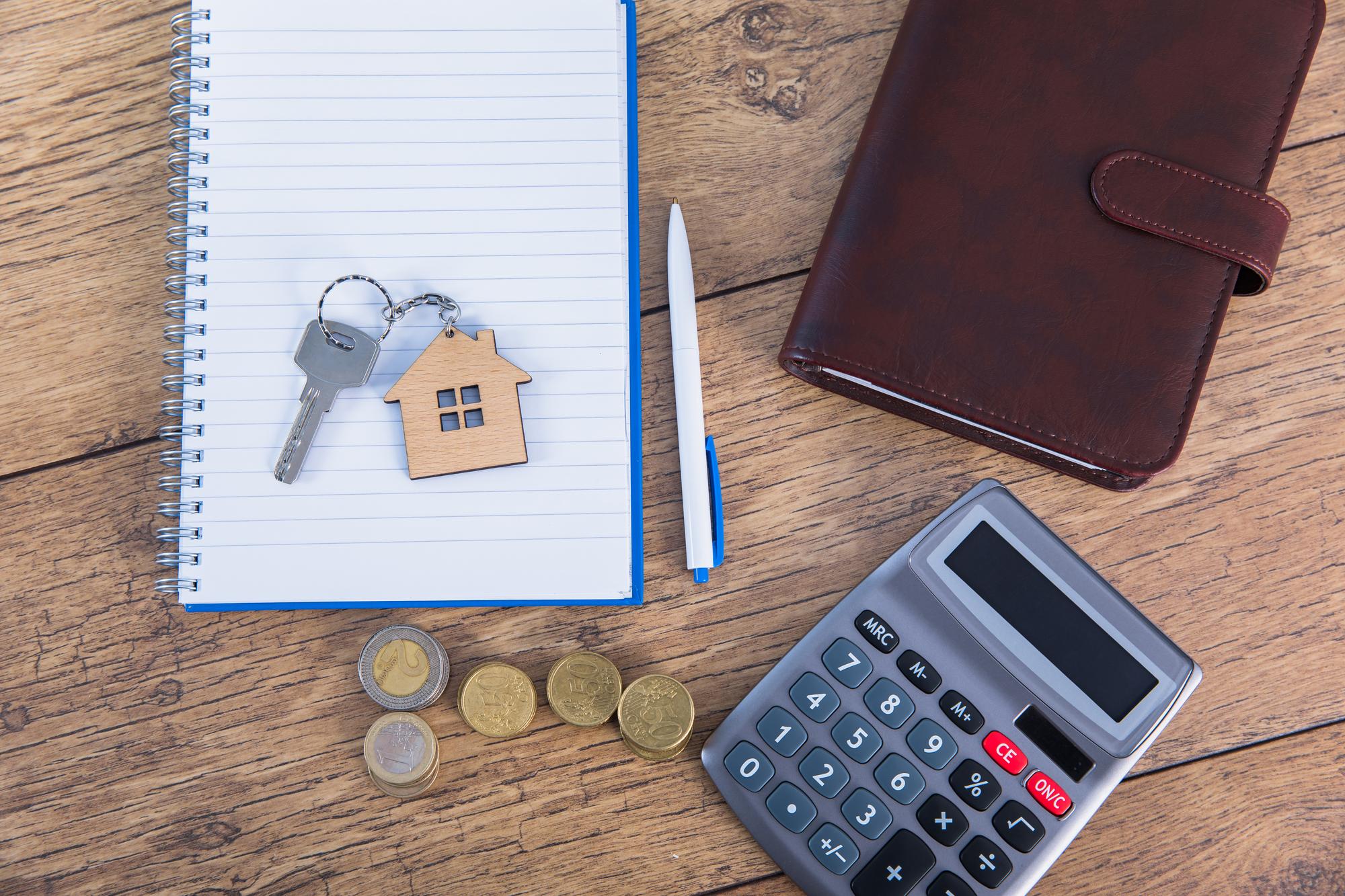 Clé de maison, carnet, pièces et calculatrice pour préparer un budget immobilier