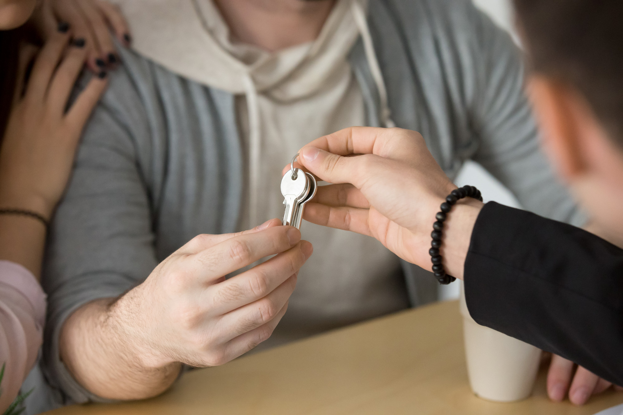 Professionnel remettant les clés d’un logement à un couple